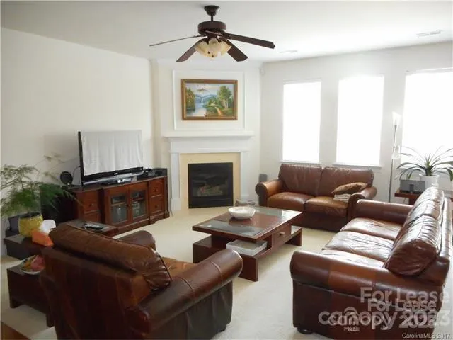 a living room with furniture a fireplace and a window