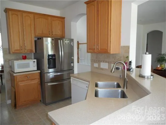a kitchen with a refrigerator sink and cabinets