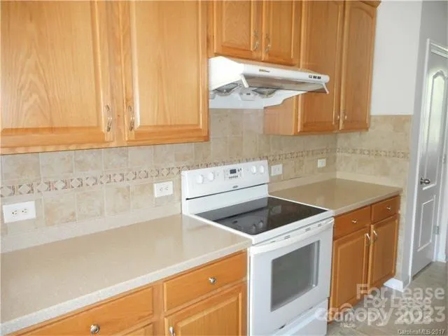 a kitchen with cabinets and a stove top oven