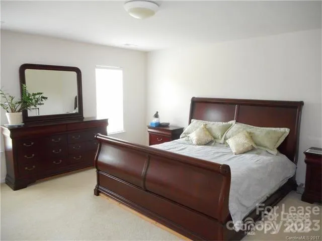 a large bed sitting in a bedroom and dresser