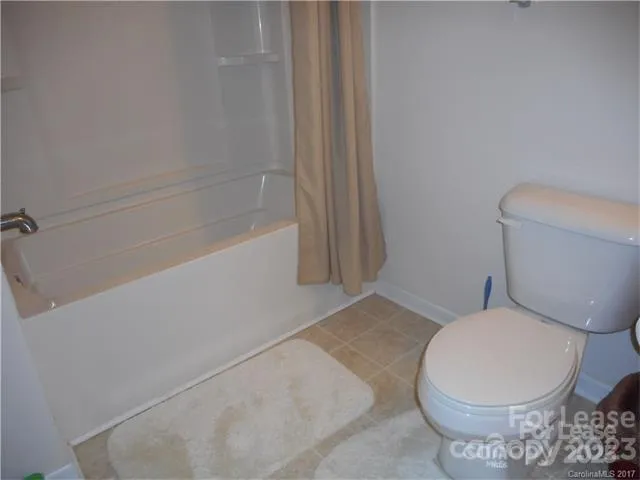 a white toilet sitting next to a bath tub