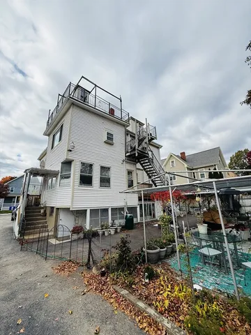 a view of a house with a wooden deck and furniture