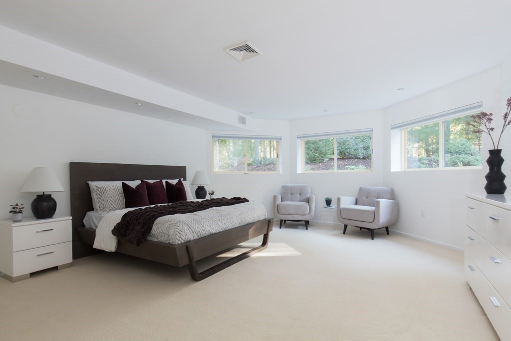 83 McAllister Drive Carlisle, MA 01741 - Photo 24 of 30 a spacious bedroom with a bed and wooden floor