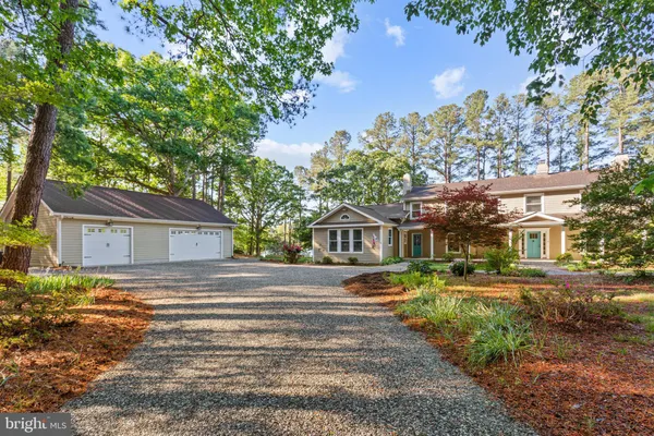 a front view of a house with a yard and trees