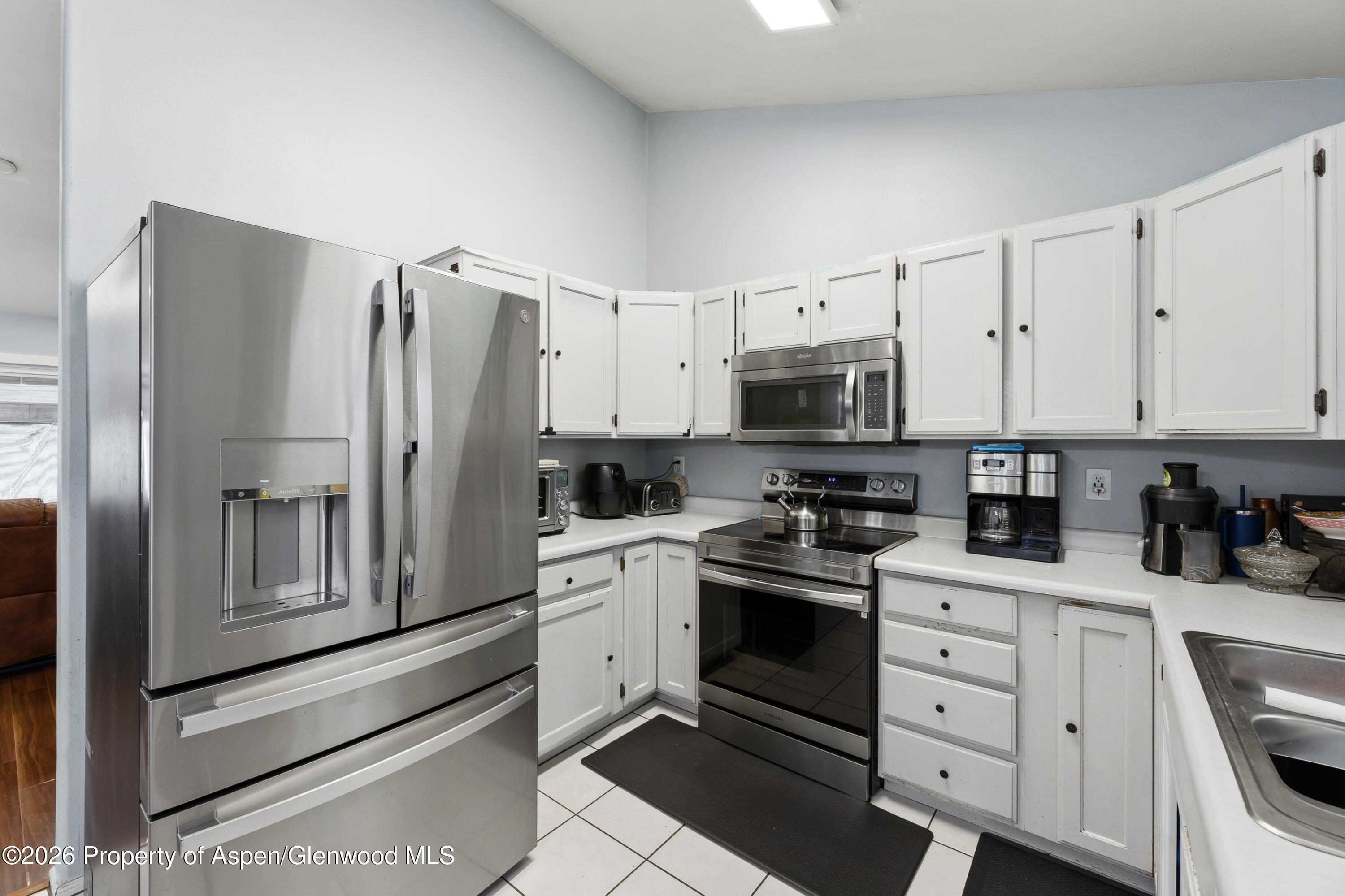 164 Current Drive New Castle, CO 81647 - Photo 14 of 34 a kitchen with white cabinets and stainless steel appliances