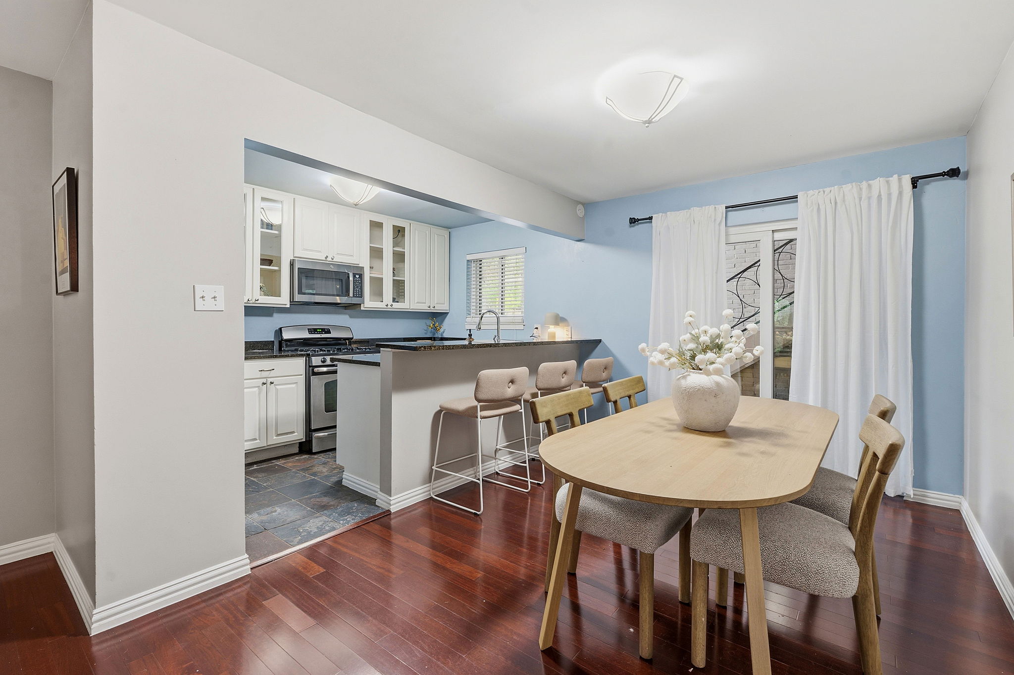 1210 Windsor Road, Unit 104 Austin, TX 78703 - Photo 7 of 29 Rich hardwood floors unite this inviting open-concept kitchen and dining area.