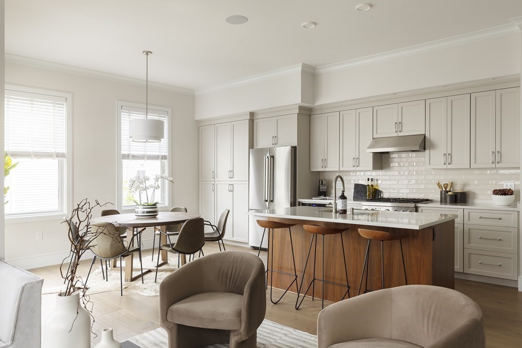 a kitchen with stainless steel appliances granite countertop a white cabinets and a stove top oven