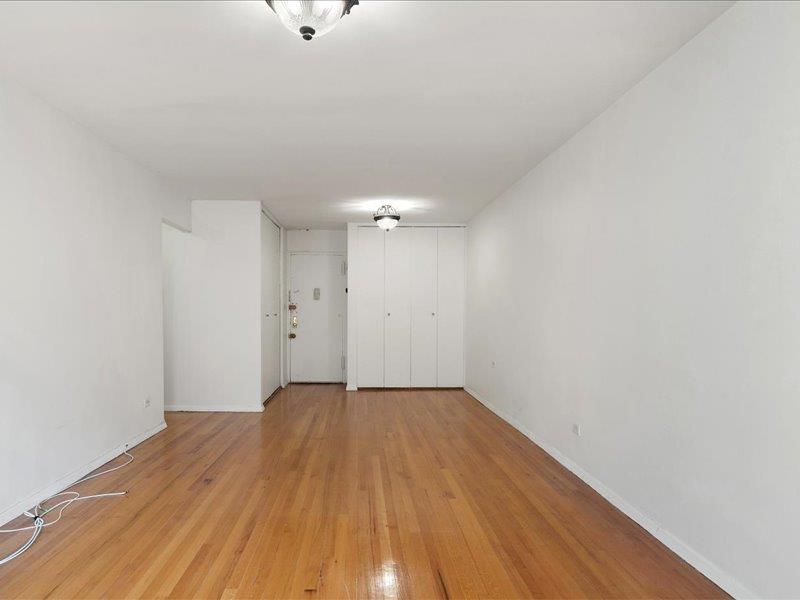 665 Thwaites Place, Unit 3N Bronx, NY 10467 - Photo 3 of 10 an empty room with wooden floor and windows