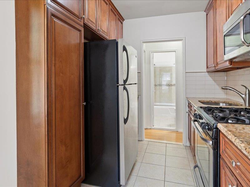 665 Thwaites Place, Unit 3N Bronx, NY 10467 - Photo 5 of 10 a kitchen with stainless steel appliances granite countertop a refrigerator and a stove