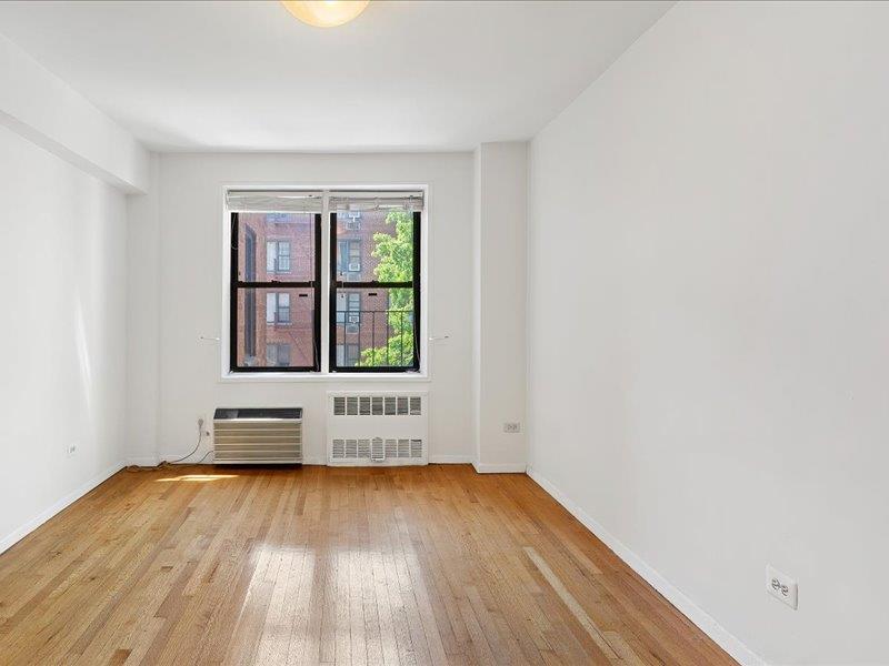 665 Thwaites Place, Unit 3N Bronx, NY 10467 - Photo 8 of 10 an empty room with wooden floor and windows