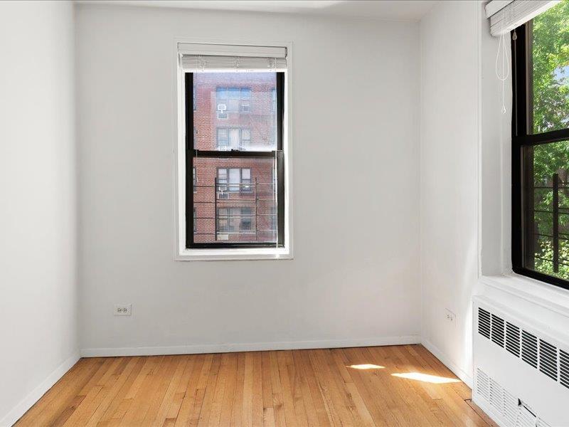 665 Thwaites Place, Unit 3N Bronx, NY 10467 - Photo 9 of 10 an empty room with wooden floor and windows
