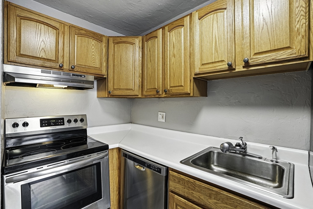 531 Main Street, Unit 410M Worcester, MA 01608 - Photo 11 of 32 a kitchen with granite countertop a sink and stainless steel appliances