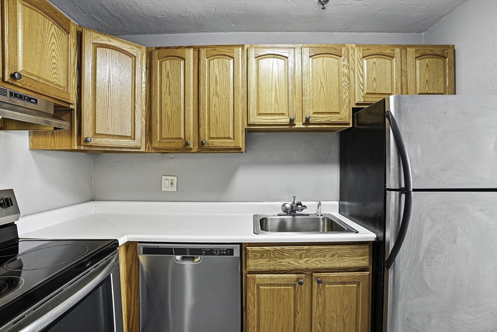 531 Main Street, Unit 410M Worcester, MA 01608 - Photo 12 of 32 a kitchen with stainless steel appliances granite countertop a refrigerator a sink and a stove