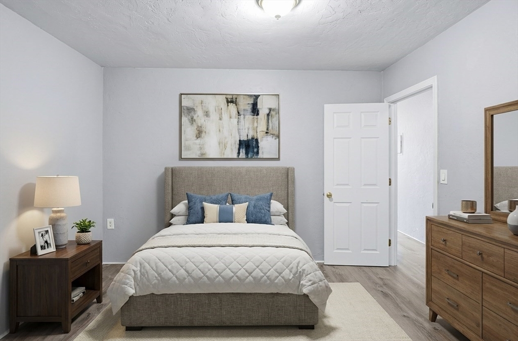 531 Main Street, Unit 410M Worcester, MA 01608 - Photo 14 of 32 a bedroom with a bed and painting on the wall