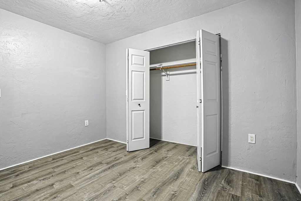 531 Main Street, Unit 410M Worcester, MA 01608 - Photo 17 of 32 an empty room with wooden floor and closet
