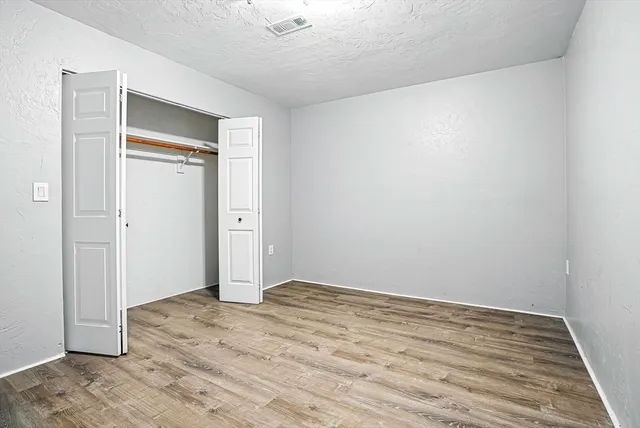 an empty room with wooden floor and closet