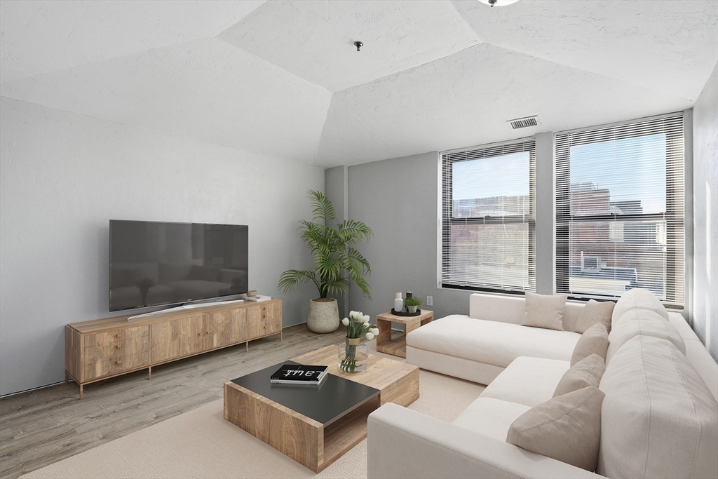 531 Main Street, Unit 410M Worcester, MA 01608 - Photo 5 of 32 a living room with furniture and a flat screen tv