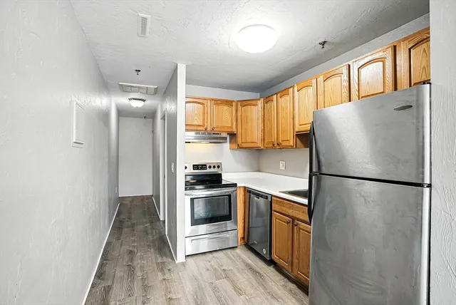 a kitchen with granite countertop a sink and stainless steel appliances