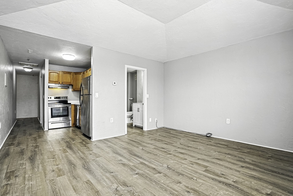 531 Main Street, Unit 410M Worcester, MA 01608 - Photo 9 of 29 a view of kitchen and empty room with wooden floor