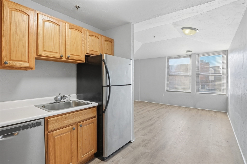 531 Main Street, Unit 410M Worcester, MA 01608 - Photo 9 of 32 a kitchen with stainless steel appliances granite countertop a refrigerator sink and cabinets