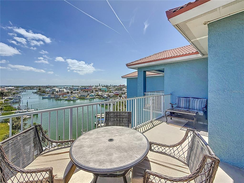 13999 Gulf Boulevard, Unit 501 Madeira Beach, FL 33708 - Photo 13 of 58 a view of a balcony with a table and chairs