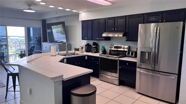 a kitchen with a refrigerator and a stove top oven
