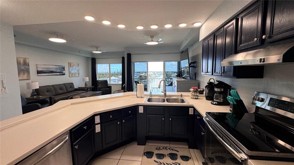 13999 Gulf Boulevard, Unit 501 Madeira Beach, FL 33708 - Photo 18 of 58 a kitchen with stainless steel appliances a sink stove and cabinets