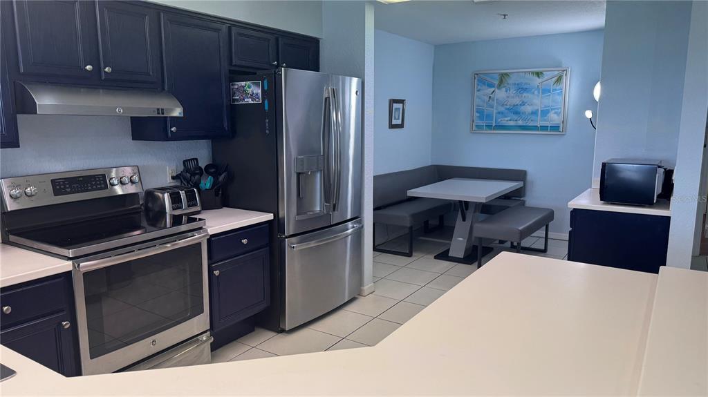 13999 Gulf Boulevard, Unit 501 Madeira Beach, FL 33708 - Photo 19 of 58 a kitchen with a refrigerator and a stove top oven