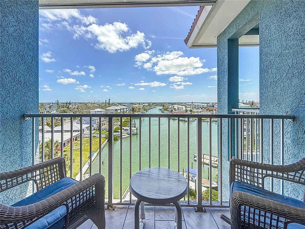 13999 Gulf Boulevard, Unit 501 Madeira Beach, FL 33708 - Photo 26 of 58 a view of a balcony with furniture and a chandelier