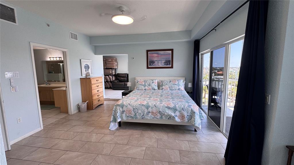 13999 Gulf Boulevard, Unit 501 Madeira Beach, FL 33708 - Photo 28 of 58 a bedroom with a bed and a refrigerator