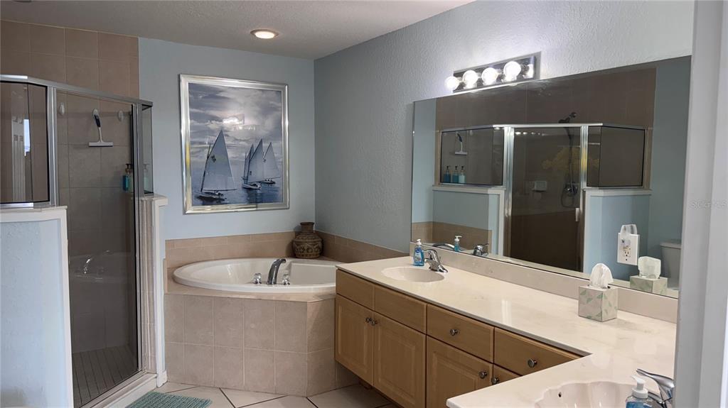 13999 Gulf Boulevard, Unit 501 Madeira Beach, FL 33708 - Photo 32 of 58 a bathroom with a double vanity sink mirror and double