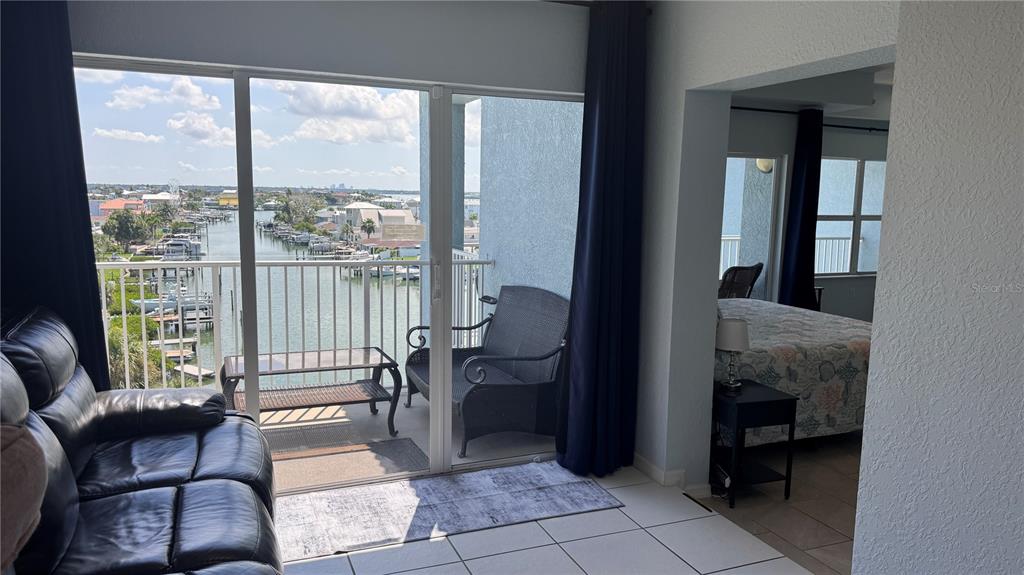 13999 Gulf Boulevard, Unit 501 Madeira Beach, FL 33708 - Photo 33 of 58 a living room with furniture and a floor to ceiling window