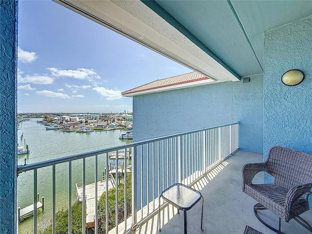 13999 Gulf Boulevard, Unit 501 Madeira Beach, FL 33708 - Photo 36 of 58 a balcony with table and chairs