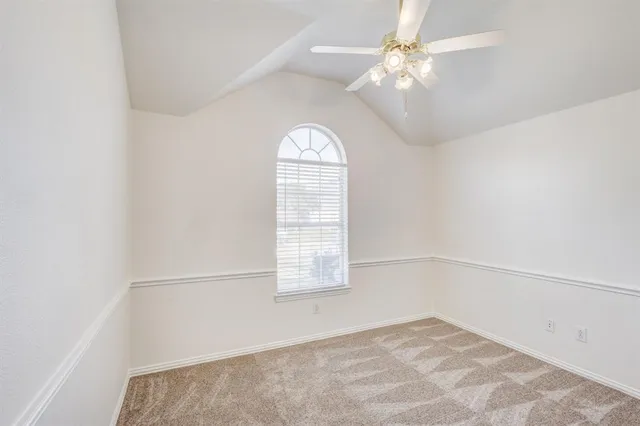 an empty room with a window and a ceiling fan