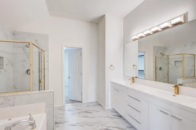 a bathroom with a double vanity sink mirror and shower