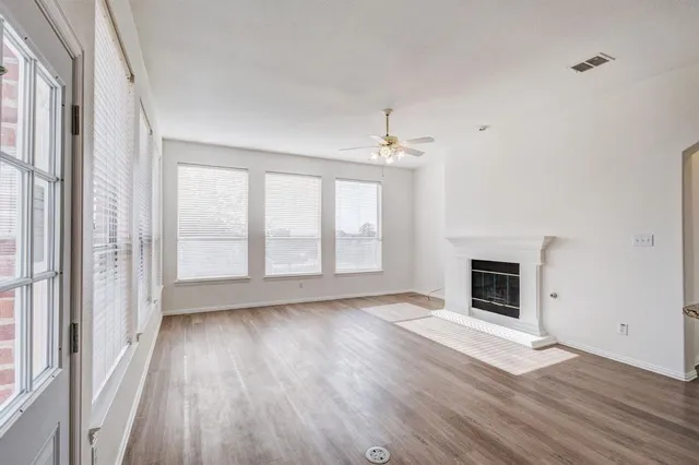 a view of empty room with wooden floor and fireplace