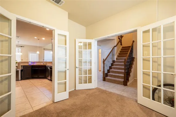 a view of a living room with a large window and kitchen view