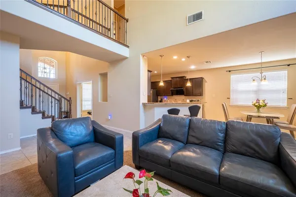 a living room with furniture and a view of kitchen