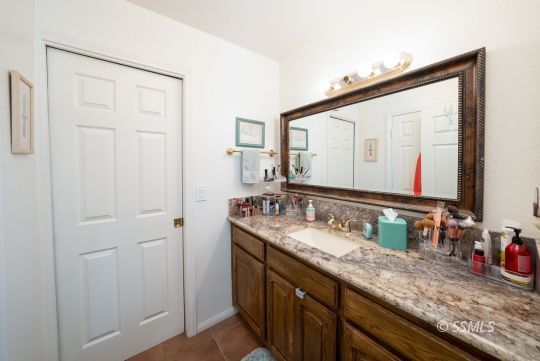 820 West Ward Avenue Ridgecrest, CA 93555 - Photo 19 of 26 a bathroom with a granite countertop sink and a mirror