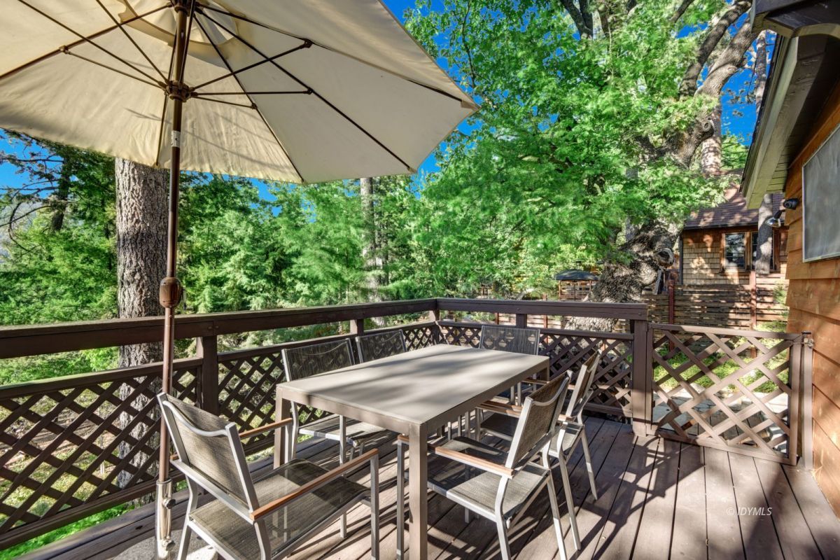 26780 Saunders Meadow Road Idyllwild, CA 92549 - Photo 12 of 41 a view of a patio with table and chairs under an umbrella