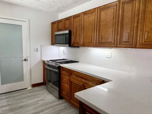 a kitchen with stainless steel appliances a stove a microwave and a sink