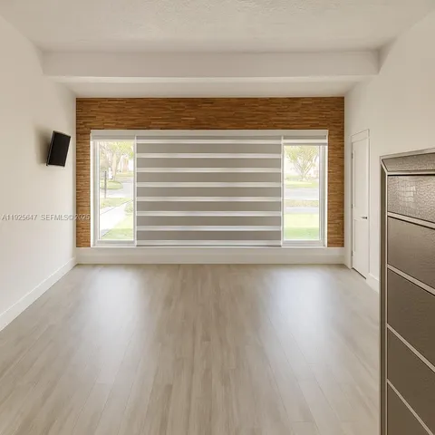 a view of a livingroom with wooden floor and a window