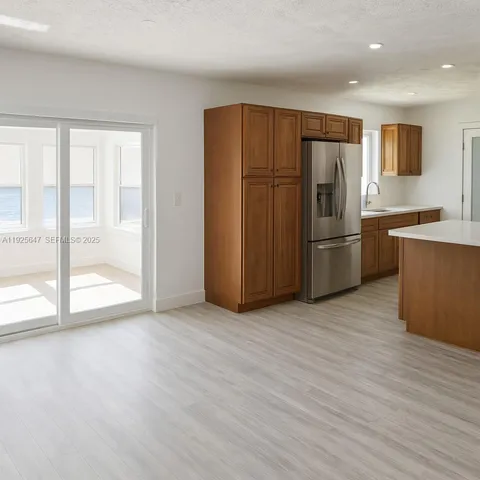 a view of kitchen with stainless steel appliances granite countertop a refrigerator and a stove top oven