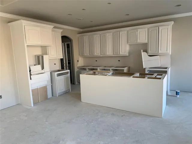 a utility room with stainless steel appliances wooden cabinet and a refrigerator