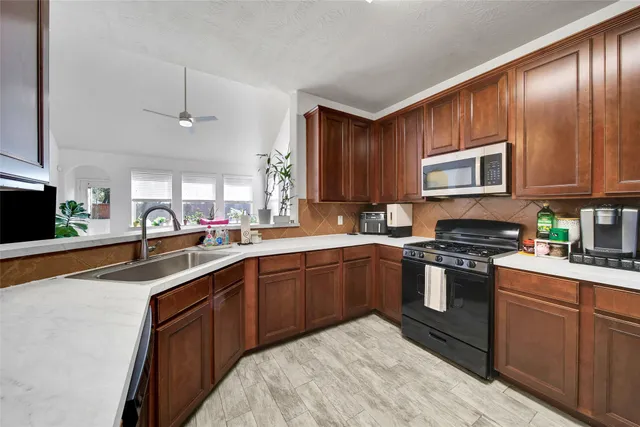 a kitchen with stainless steel appliances granite countertop a sink stove and microwave