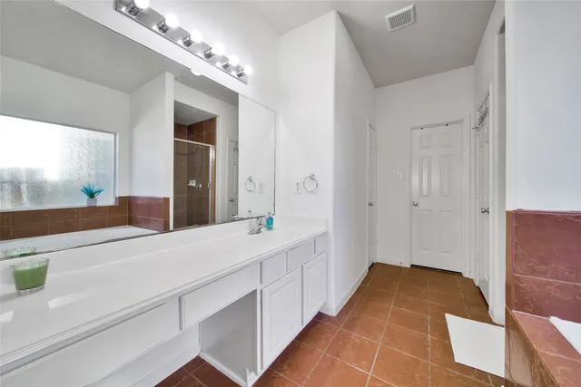 a spacious bathroom with a double vanity sink and a mirror