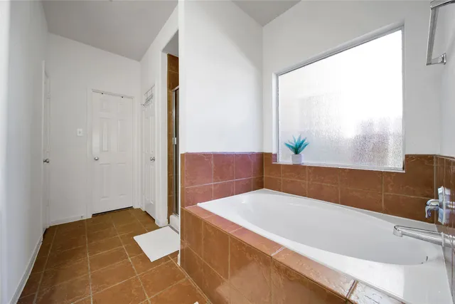 a bathroom with a bathtub and next to a window