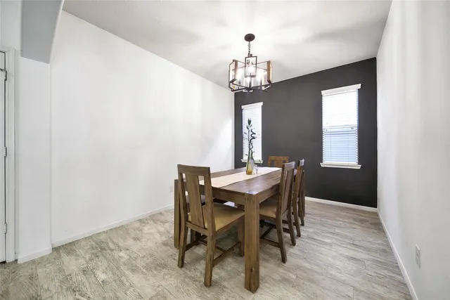 a view of a dining room with furniture a chandelier and wooden floor