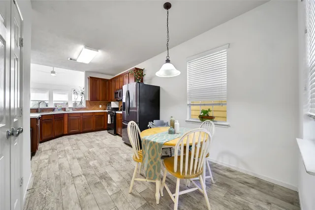 a view of a dining room with furniture a chandelier and wooden floor