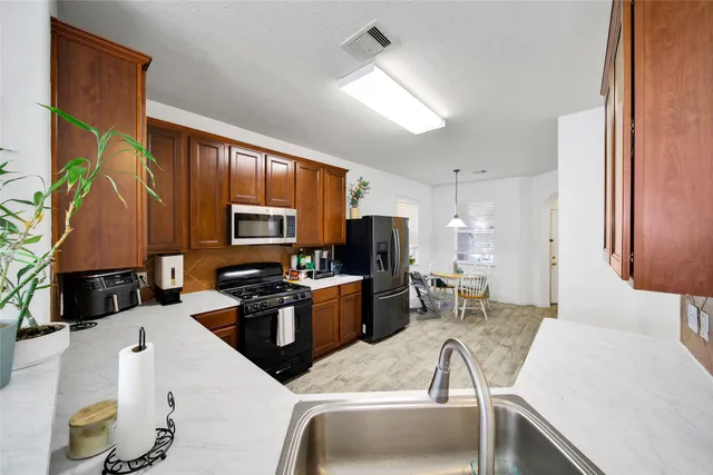 a kitchen with a sink a counter top space and stainless steel appliances